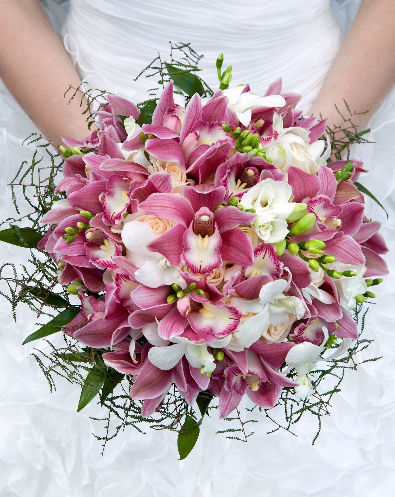 Happy bride carries a beautiful wedding bouquet of orchids and peonies Happy bride carries a beautiful wedding bouquet of orchids and peonies